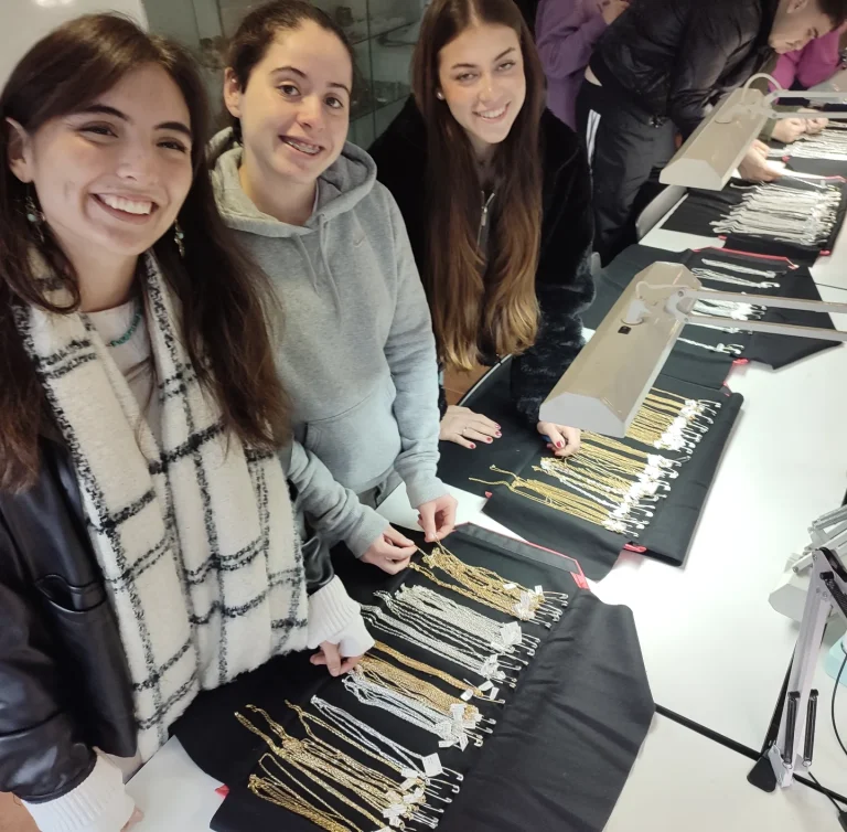 Alumnas de la Escuela Técnica de Joyería del Atlántico revisando muestrarios de cadenas de plata durante la visita de un mayorista