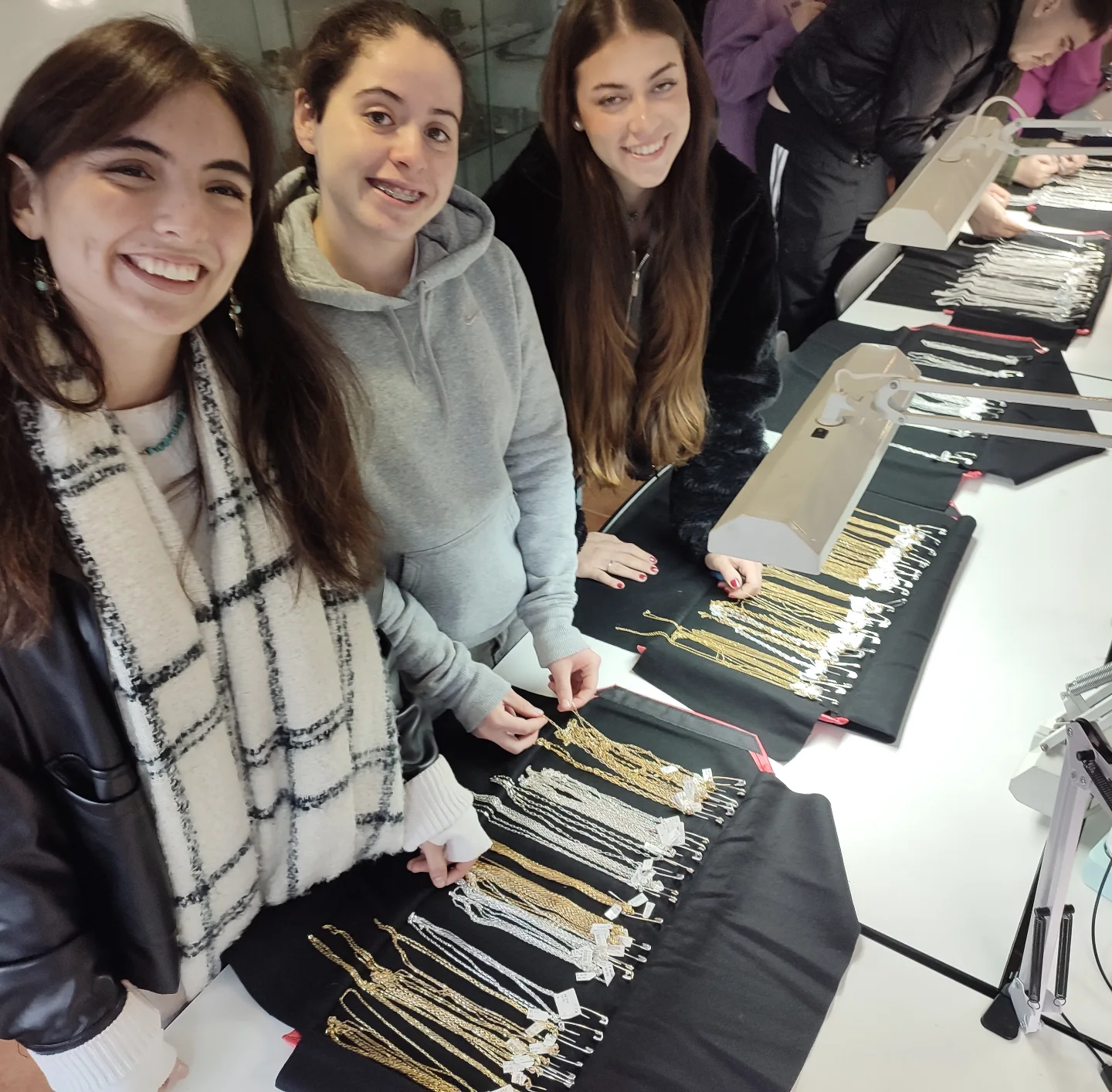 Alumnas de la Escuela Técnica de Joyería del Atlántico revisando muestrarios de cadenas de plata durante la visita de un mayorista